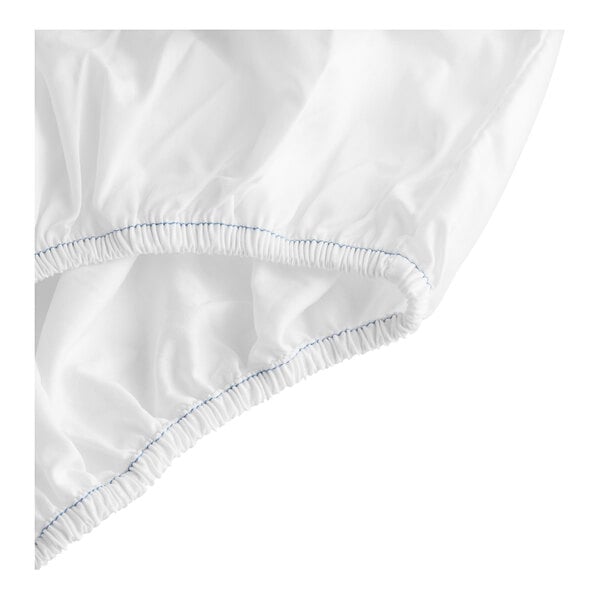 A close up of a white Garnier-Thiebaut fitted sheet with blue stitching.