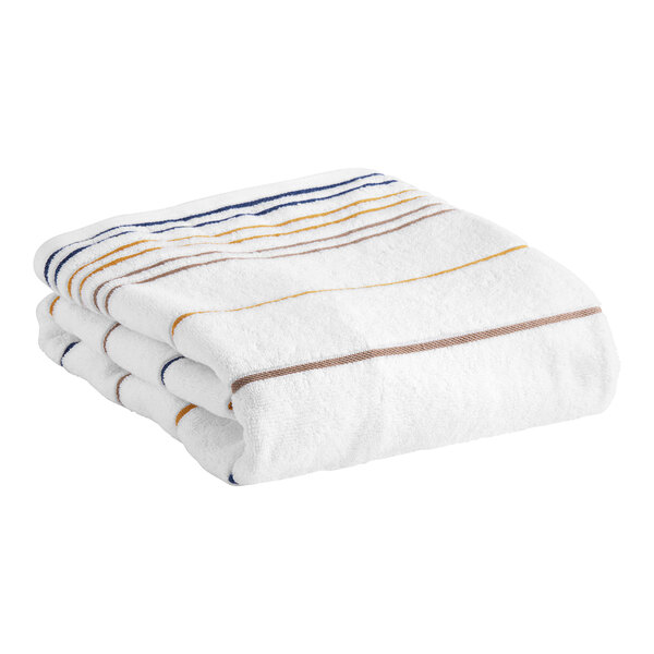 A folded white Garnier-Thiebaut pool towel with brown and blue stripes.