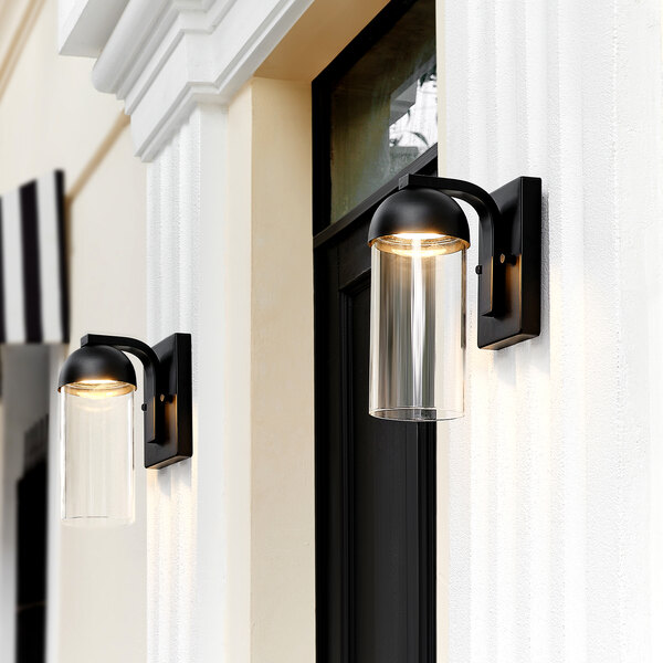 Two Globe matte black outdoor wall sconces on a white building.
