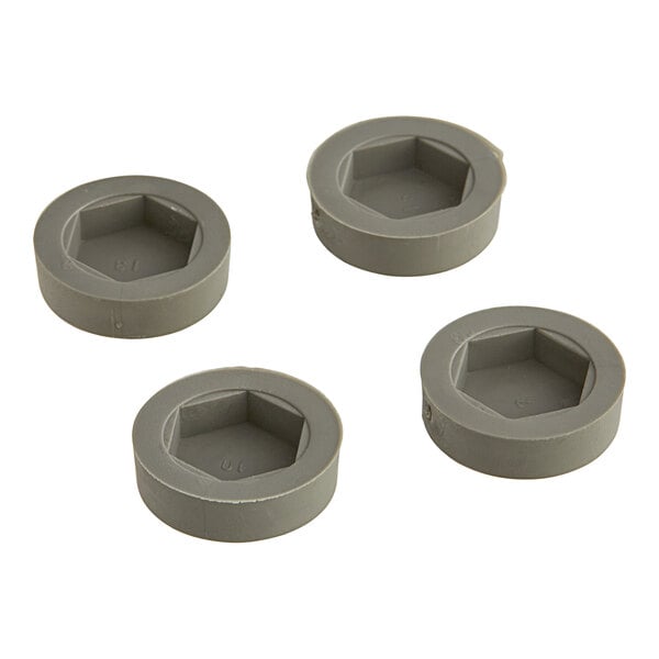 Four grey plastic Lavex Pro rubber floor glides.