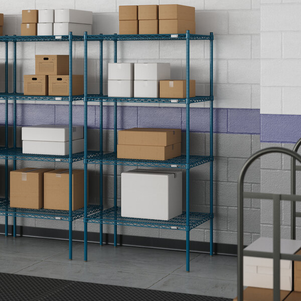 A blue Lavex wire shelf with boxes on it in a room.