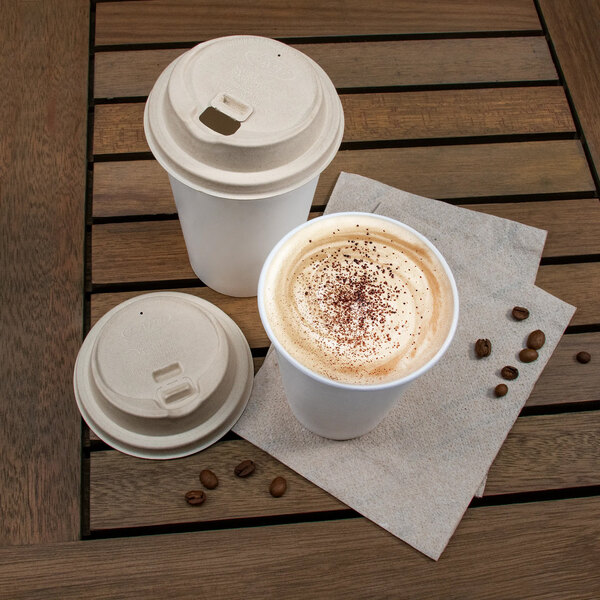 Two white Dart ProPlanet coffee cups with brown lids on a table.