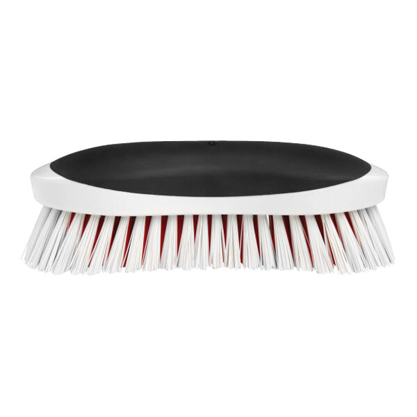 An OXO Good Grips heavy-duty scrub brush with red bristles.