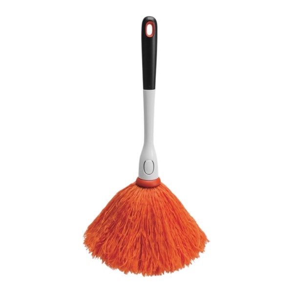 An orange and black OXO Good Grips delicate duster with a white handle.