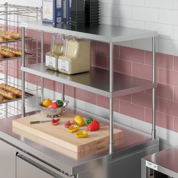 A stainless steel Avantco double deck overshelf over a counter with food on it.