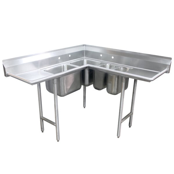 An Advance Tabco stainless steel corner sink with four compartments and two drainboards.