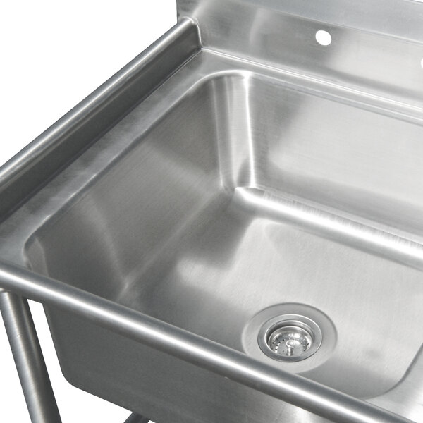An Advance Tabco stainless steel four compartment corner sink with two drainboards.