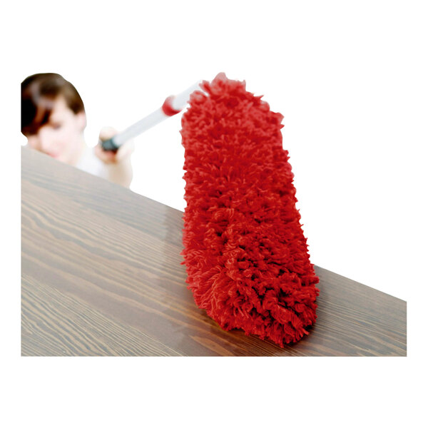 A red microfiber duster refill being used to clean a wooden surface.