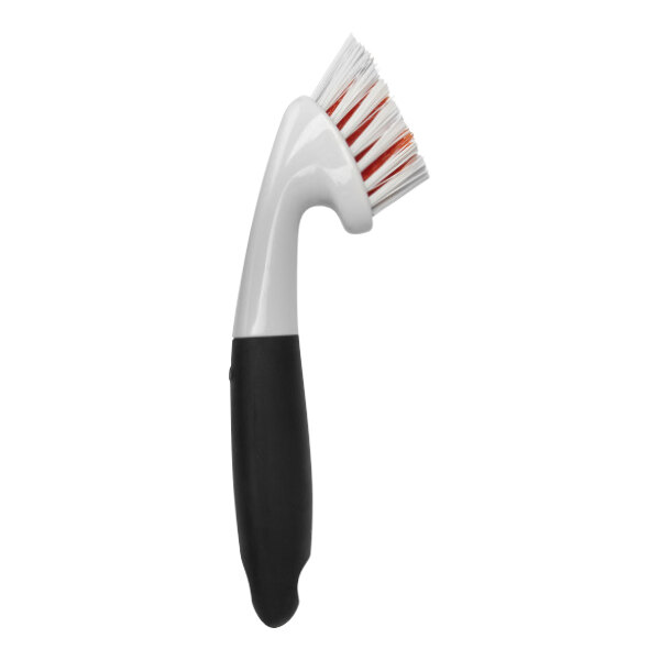 An OXO Good Grips grout brush with black and white bristles.