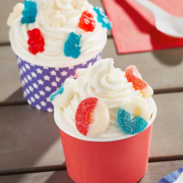 Two cupcakes with white frosting and Albanese Sanded Gummi Freedom Rings on top.