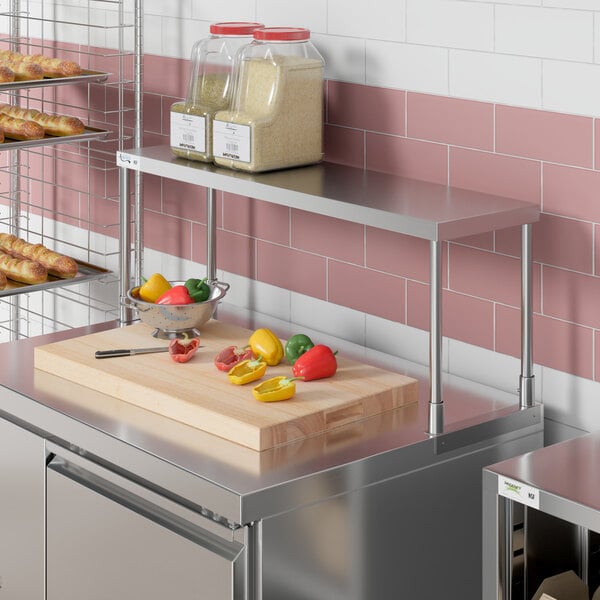 An Avantco stainless steel single deck overshelf on a counter in a kitchen.