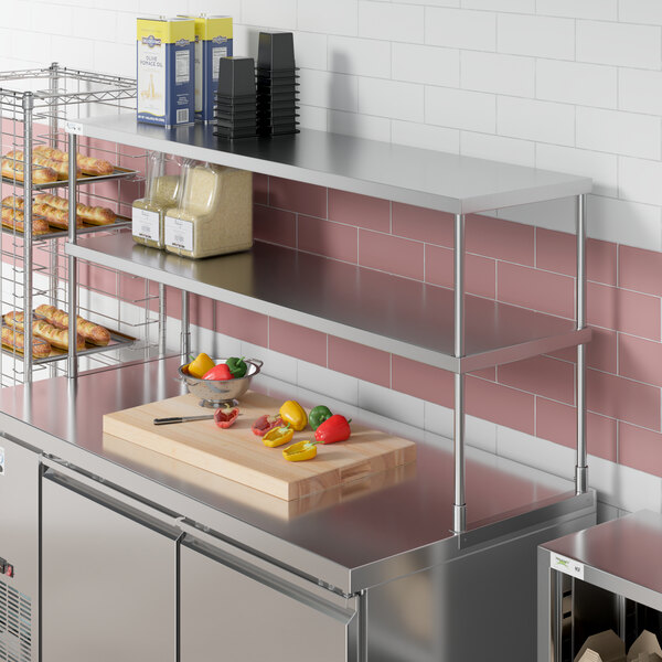 A stainless steel Avantco double deck overshelf on a counter over stainless steel shelves.