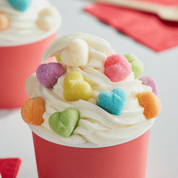 A cup of ice cream with Albanese sanded gummi hearts on top.