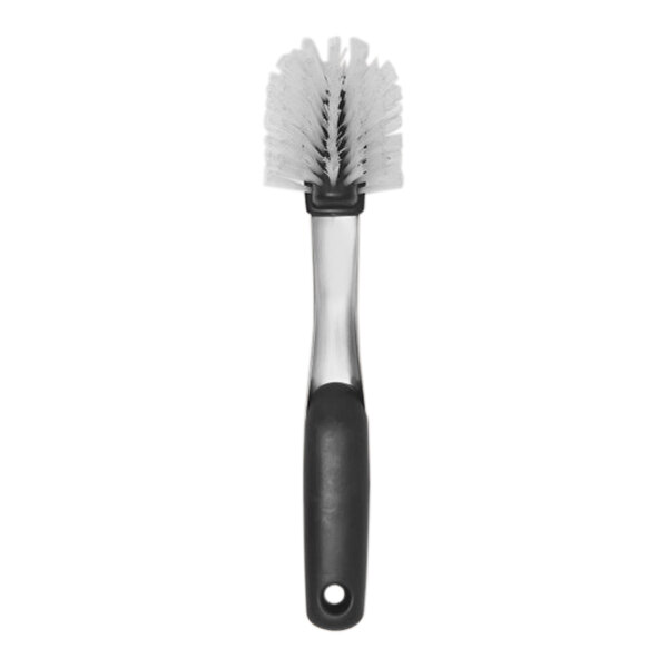 An OXO SteeL stainless steel dish brush with a black and white handle.