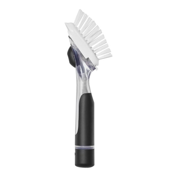 An OXO Good Grips soap dispensing dish brush with a black and white handle.