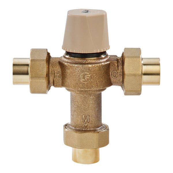 A close-up of a Watts brass thermostatic mixing valve with two brass handles.