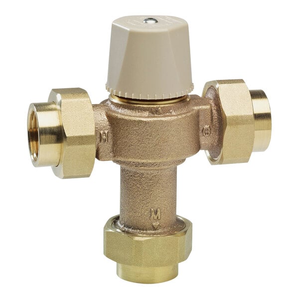 A close-up of a Watts brass thermostatic mixing valve with two brass valves.