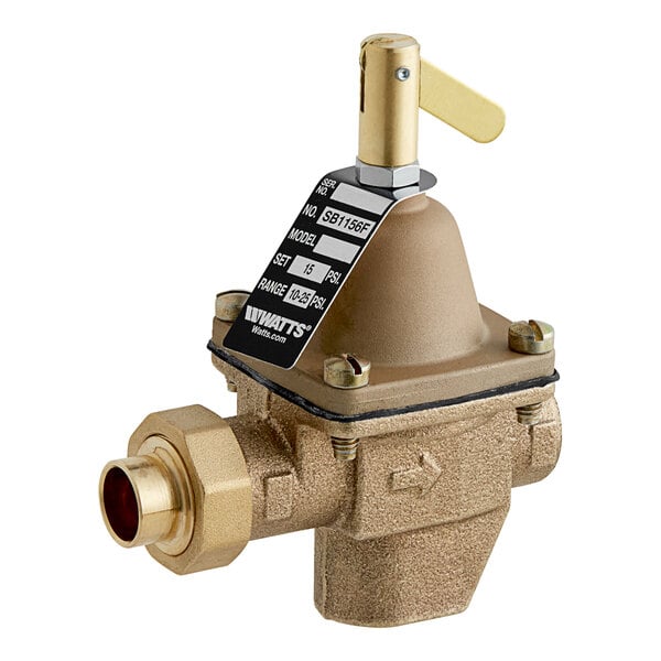 A close-up of a brass Watts feed water pressure regulator valve with a gold handle.