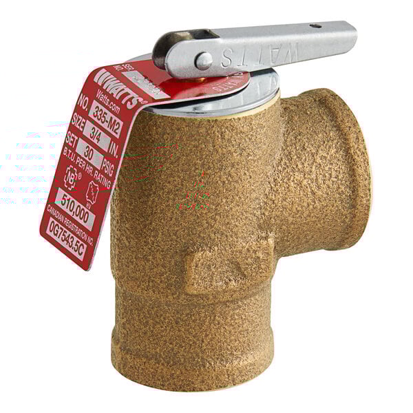 A close-up of a Watts bronze boiler pressure relief valve with a red tag.
