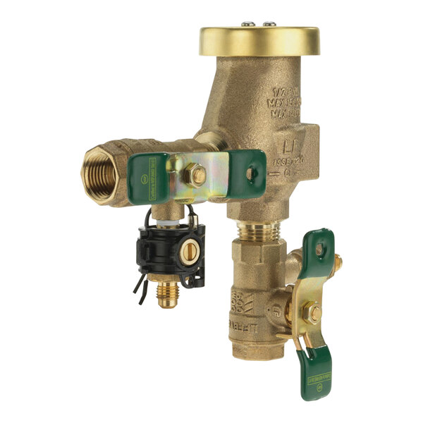 A close-up of a Watts brass pressure vacuum breaker with green and gold handles.