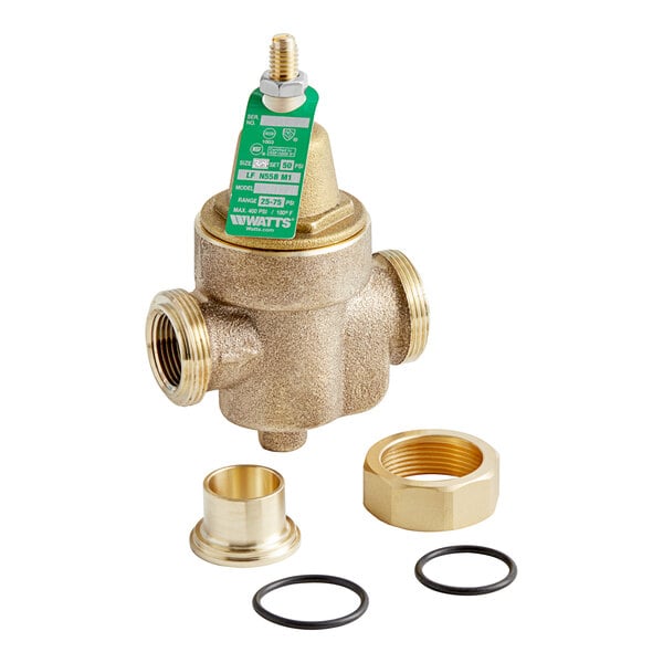 A close-up of a Watts brass water pressure reducing valve with a brass nut and black gaskets.