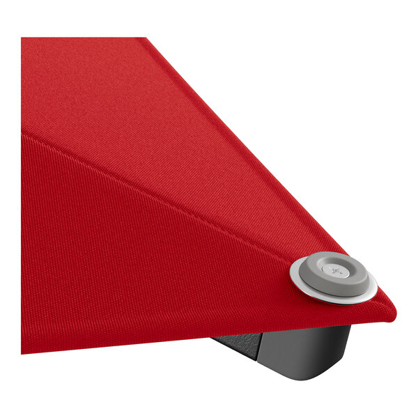 The red fabric of a Lancaster Table & Seating square umbrella with a black metal pulley lift button.