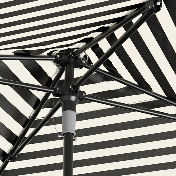 A black and white striped umbrella with a black pole.