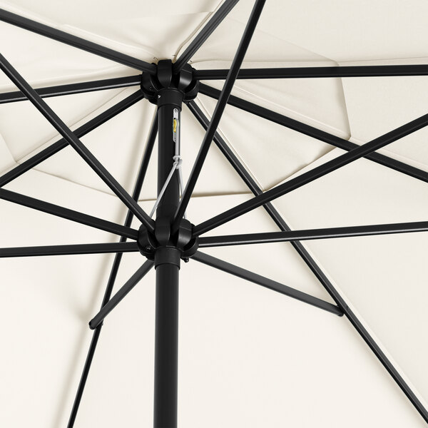 A close up of a Lancaster Table & Seating white umbrella with a black steel base.