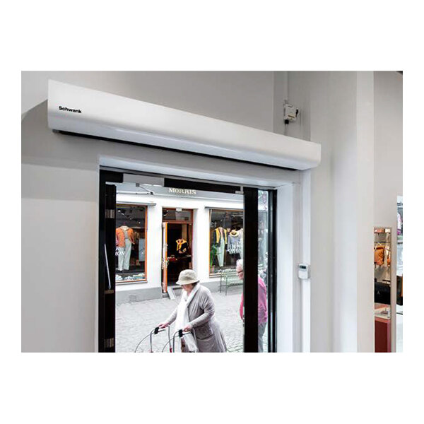 A white electric heated air curtain installed above a commercial doorway.