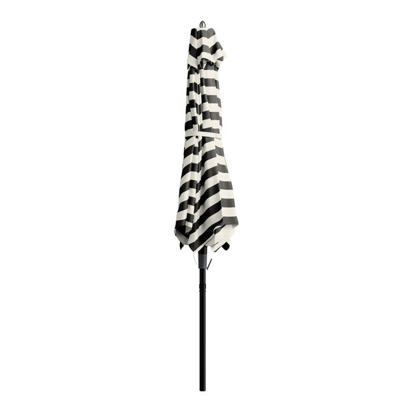 A Lancaster Table & Seating black and white striped umbrella on a stand.