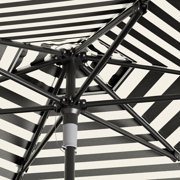 A black and white striped umbrella with a black metal pole.