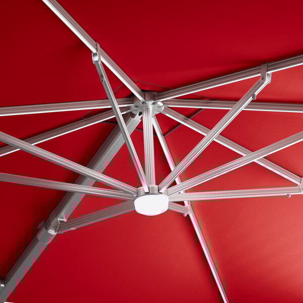 A red Lancaster Table & Seating cantilever umbrella with a metal frame.