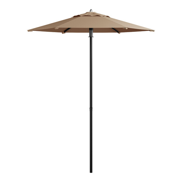 A tan umbrella on a black pole.