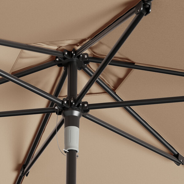 A Lancaster Table & Seating round wheat umbrella with a black metal pole open.