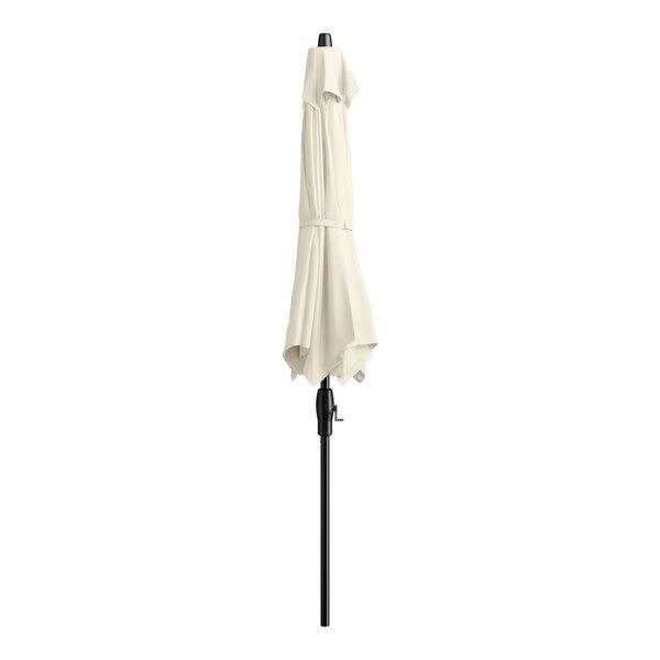 A Lancaster Table & Seating ivory umbrella on a black pole.