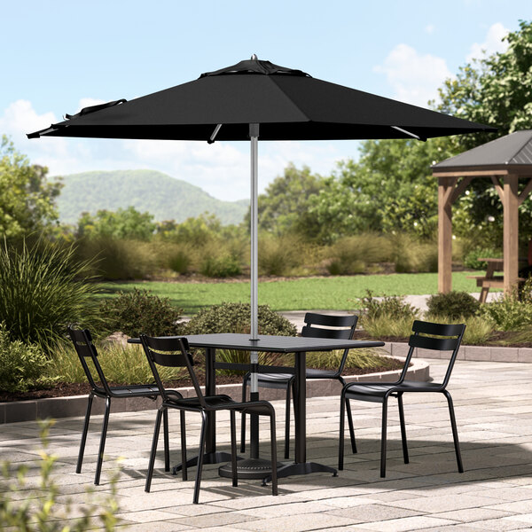 A patio table with chairs under a black Lancaster Table & Seating umbrella.