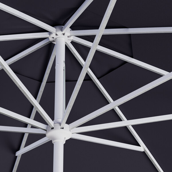 A close up of a navy blue Lancaster Table & Seating round umbrella with a silver pole.