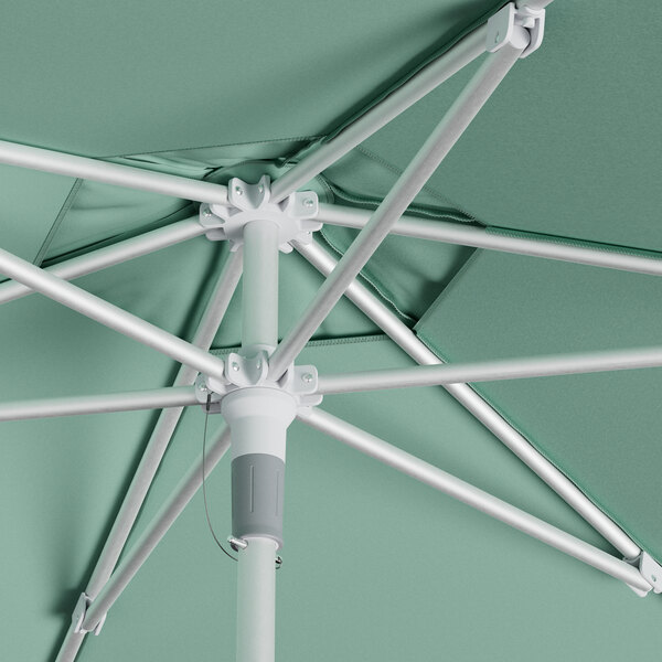 A white Lancaster Table & Seating round umbrella with silver poles.