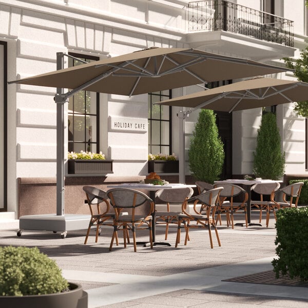 A table and chairs under a Lancaster Table & Seating cantilever umbrella.