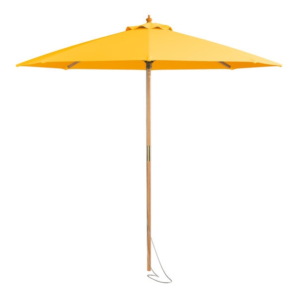 A close up of a Lancaster Table & Seating canary yellow umbrella with a wooden pole.