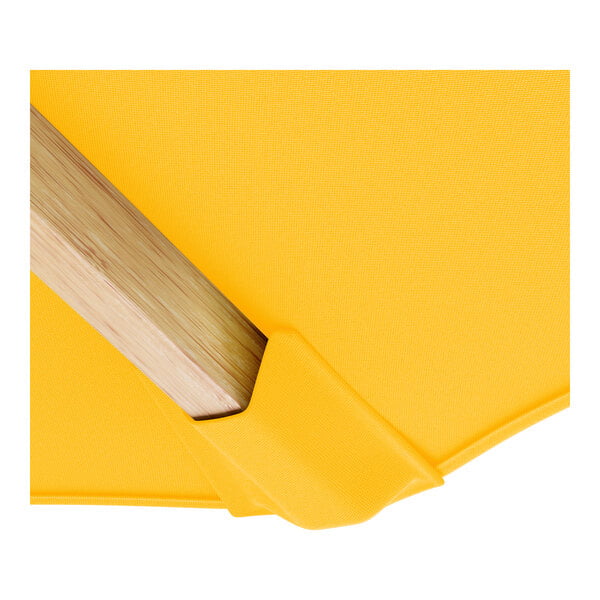 A Lancaster Table & Seating round yellow umbrella with a wooden pulley lift handle.