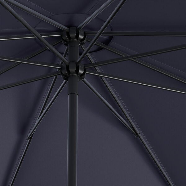 A close up of a black Lancaster Table & Seating round umbrella with a black metal pole.