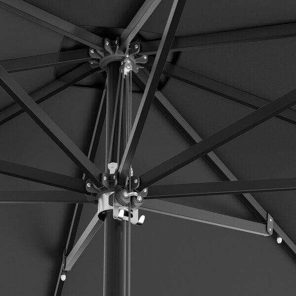 A close up of a black Lancaster Table & Seating square umbrella with black metal poles.