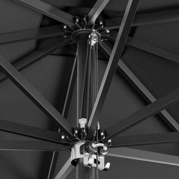 A close up of a black Lancaster Table & Seating square umbrella with black aluminum poles.