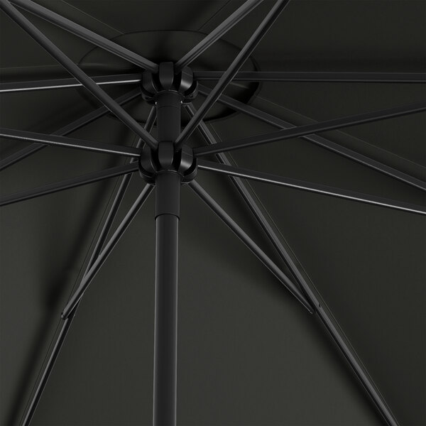 A black Lancaster Table & Seating umbrella with metal rods.