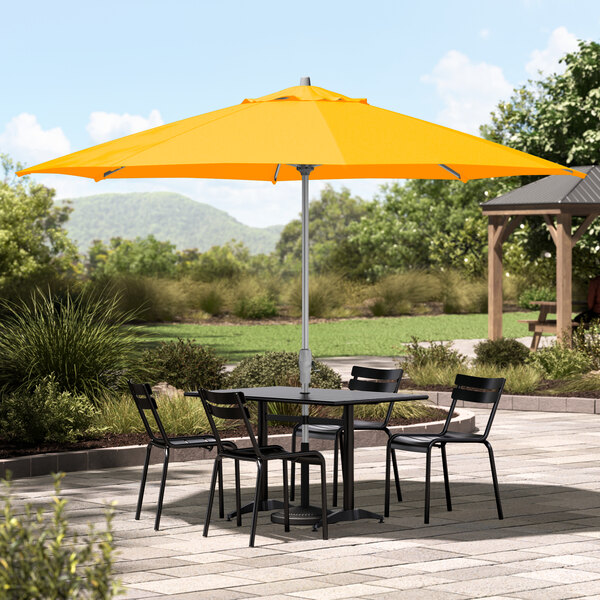 A yellow Lancaster Table & Seating umbrella on a patio table.