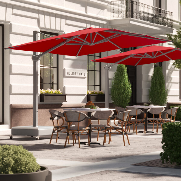 A patio with tables and chairs under red Lancaster Table & Seating cantilever umbrellas.