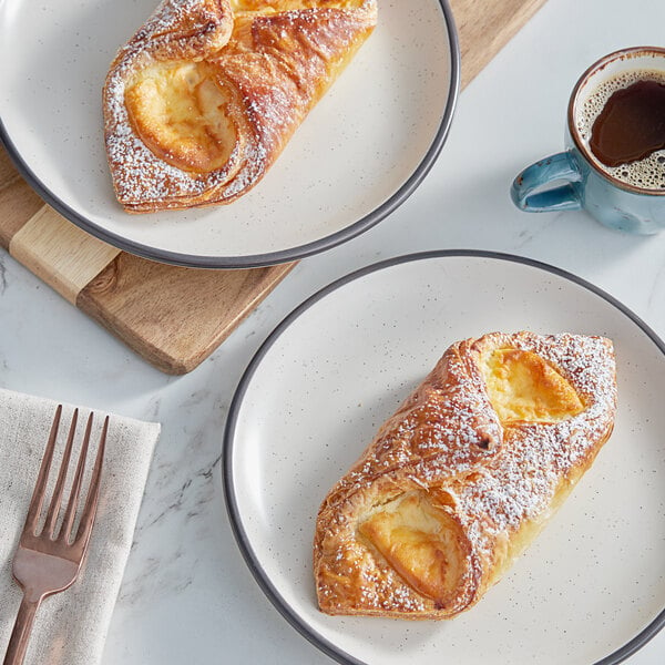 A plate of pastries with a fork next to a cup of coffee.