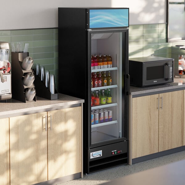 An Avantco black merchandising refrigerator with a left-hinged glass door full of drinks.