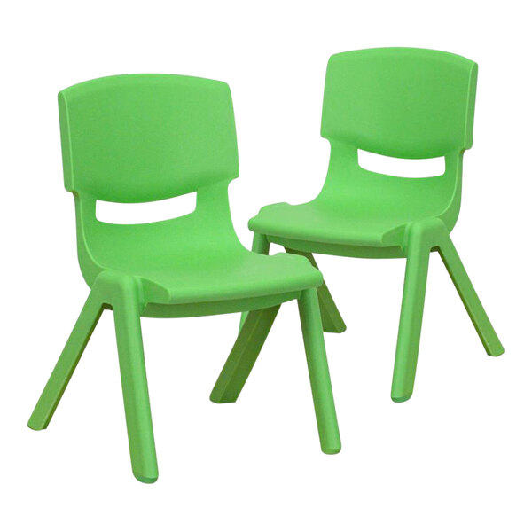 A pair of green plastic chairs with legs.